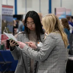 Two students looking at a job resume